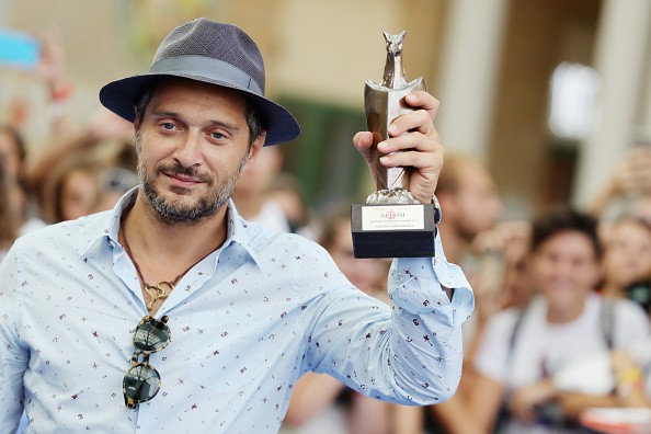 GIFFONI VALLE PIANA, ITALY - JULY 22: Claudio Santamaria poses with the Giffoni Experience Award during Giffoni Film Festival Day 9 blue carpet on July 23, 2016 in Giffoni Valle Piana, Italy. (Photo by Stefania D'Alessandro/Getty Images for Giffoni Film Festival)