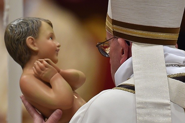 Pope Francis carries the statue of baby Jesus during a mass on Christmas eve marking the birth of Jesus Christ on December 24, 2015 at St Peter's basilica in Vatican. AFP PHOTO / VINCENZO PINTO / AFP / VINCENZO PINTO (Photo credit should read VINCENZO PINTO/AFP/Getty Images)